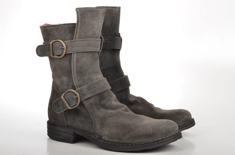 a pair of grey boots with straps and buckles