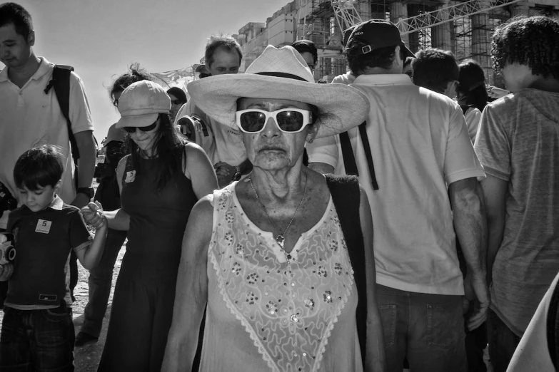 people gathered around in hats and dresses at an outdoor event