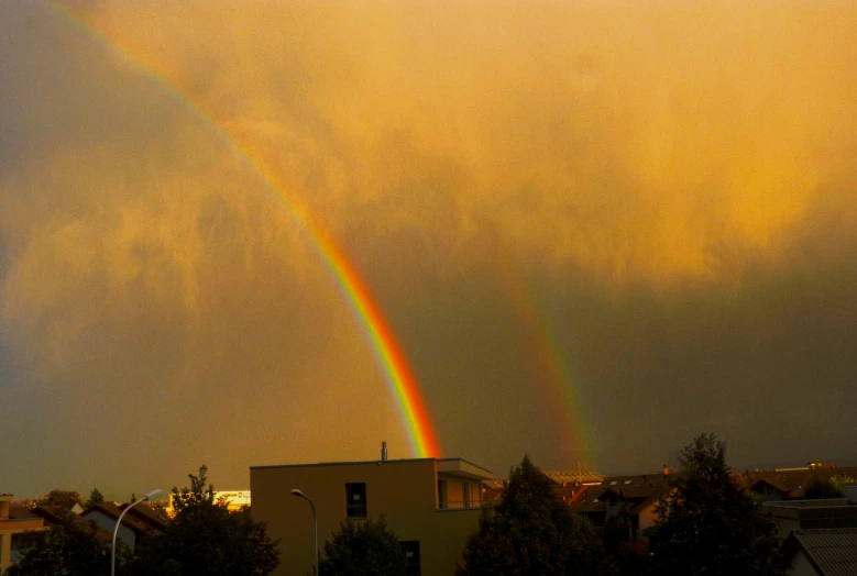 a rainbow appears in the sky over houses