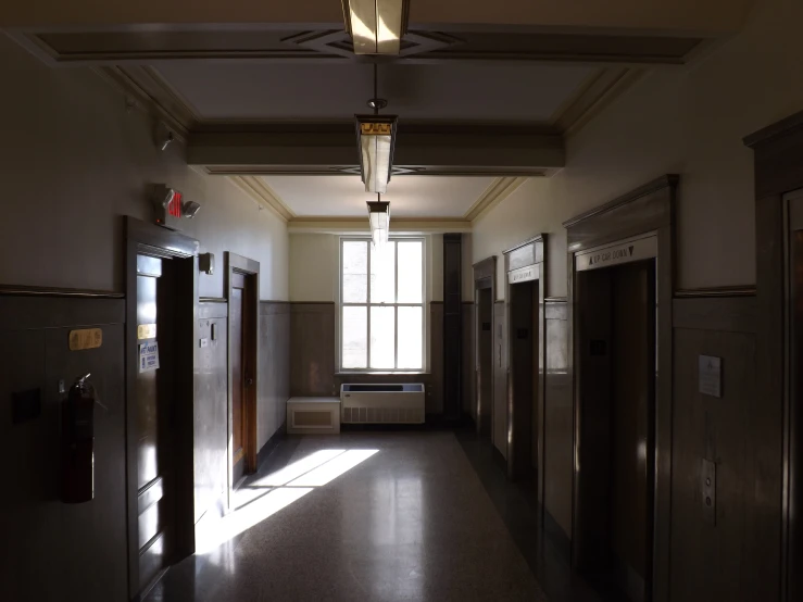 a hallway has wooden doors, wood ceiling, and a clock