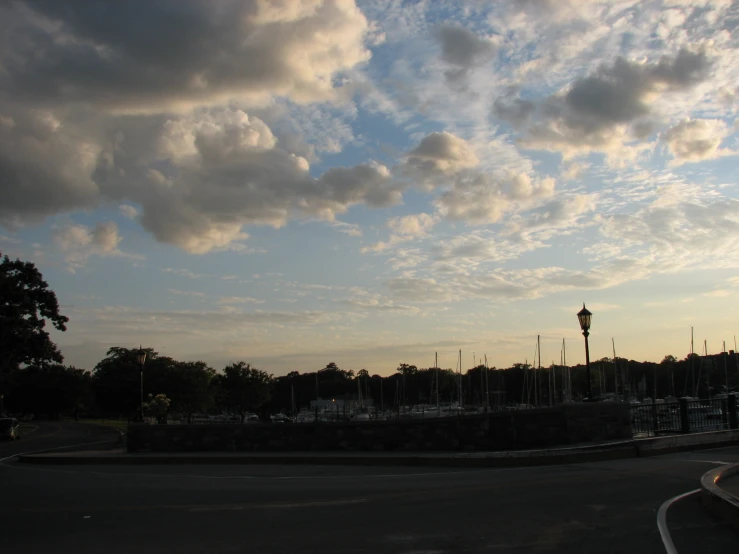 a road with a fence and buildings on the sides at dusk