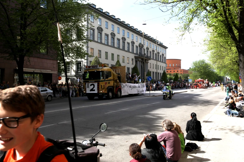 people watching a parade being observed by a tour bus