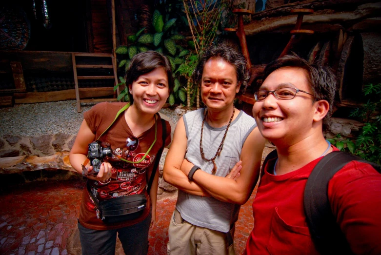 two men and a woman are smiling at the camera