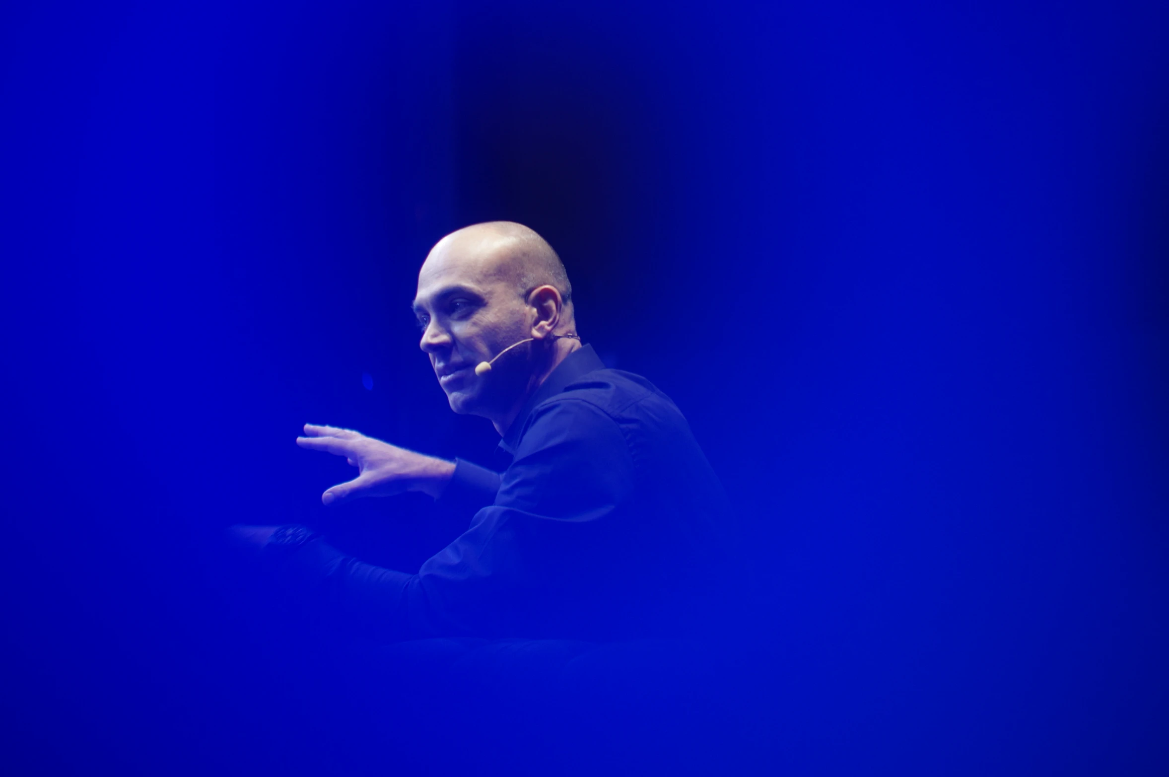 a man in black shirt and dark eyes on stage