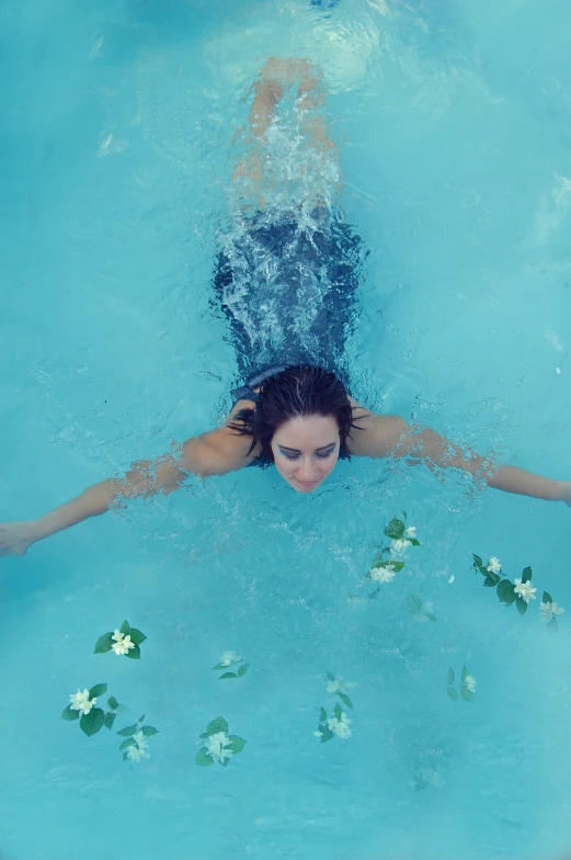 a girl is swimming in a pool full of water