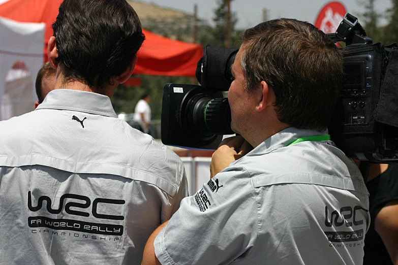 two men wearing white shirts are shown in front of a camera