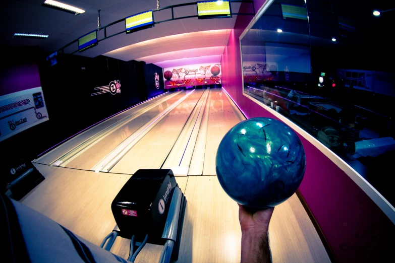 a bowling alley has a bowling ball thrown into the lane