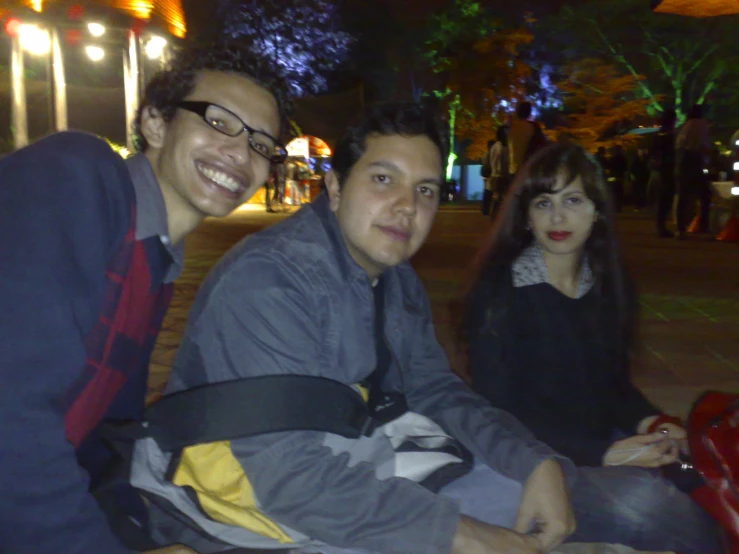 two friends sit together on the side walk