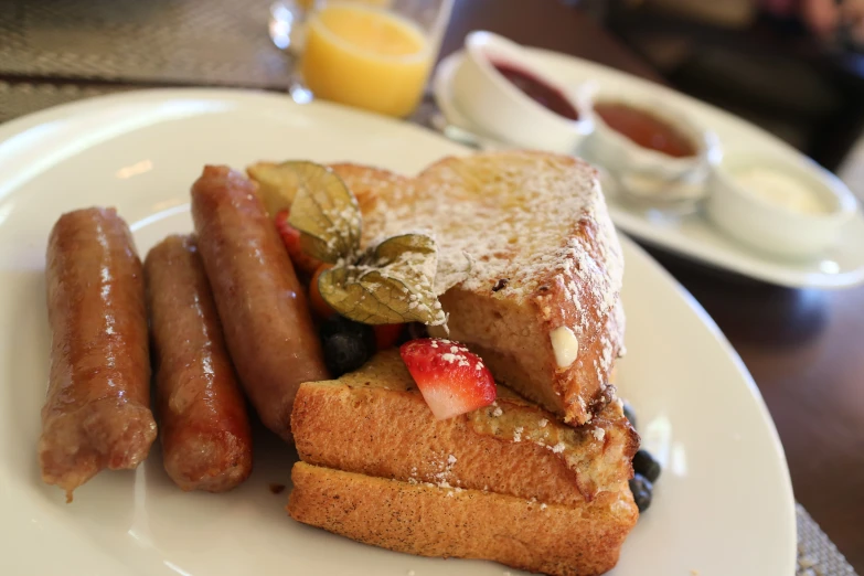 some bacon and fruits are on a plate