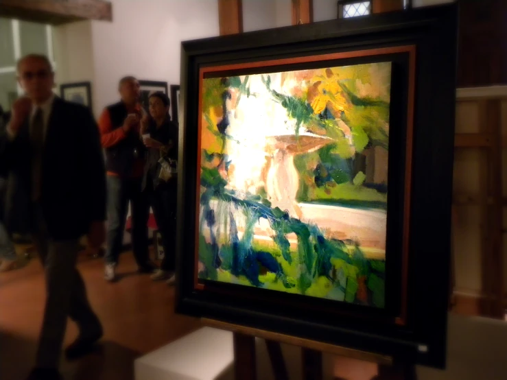 an art exhibit featuring a painting with people standing around