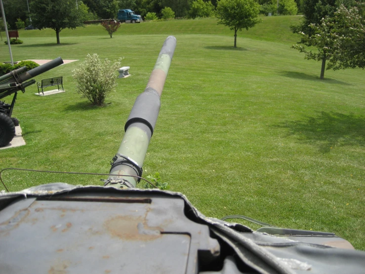 a large metal pipe next to a park with benches