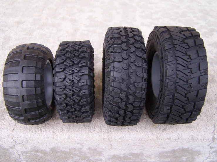 a bunch of four black tires sitting on top of carpet