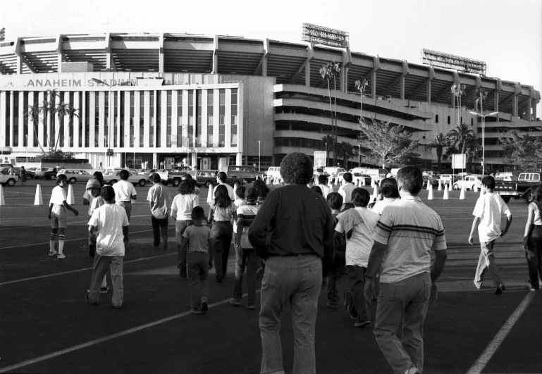 many people walk outside an open stadium