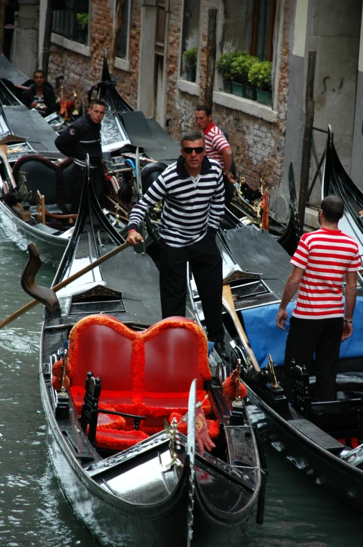 a man in striped shirt standing on top of a boat