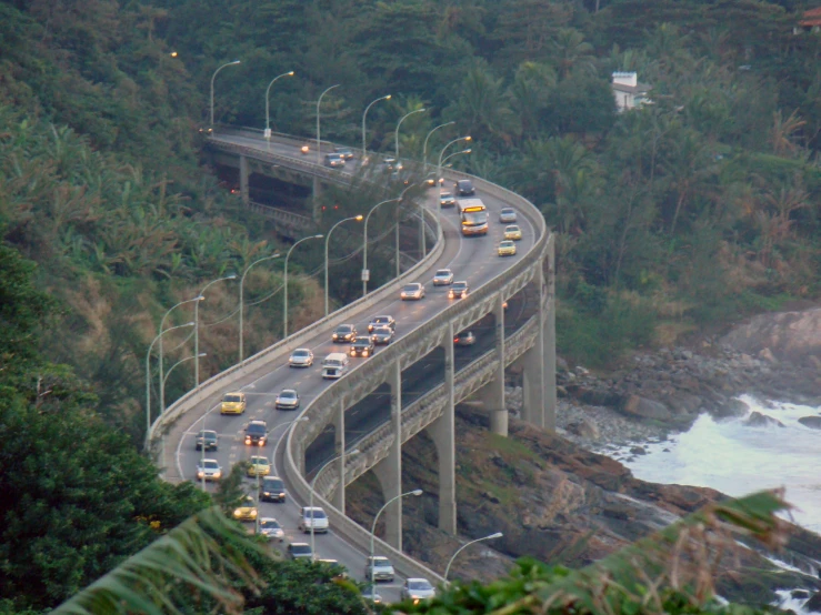 a busy road with a view of the coast in the distance