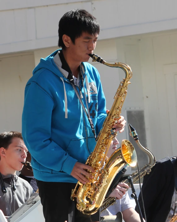 a guy plays on his saxophone while people watch