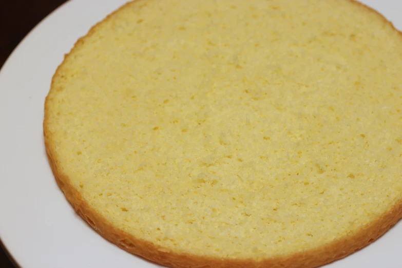 a yellow cake on a white plate on a table