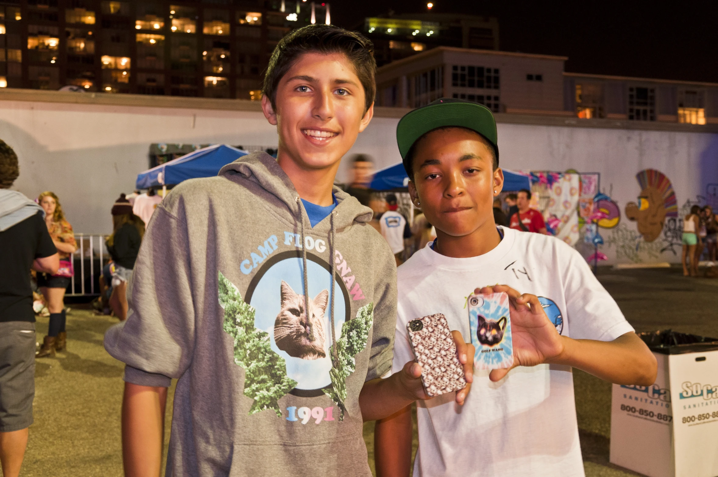 two boys posing with some doughnuts in hand