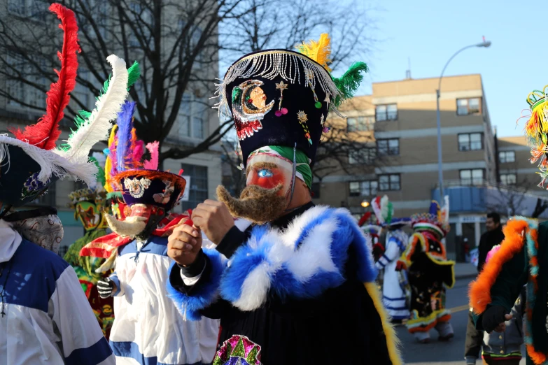 group of people in carnival masks in front of buildings