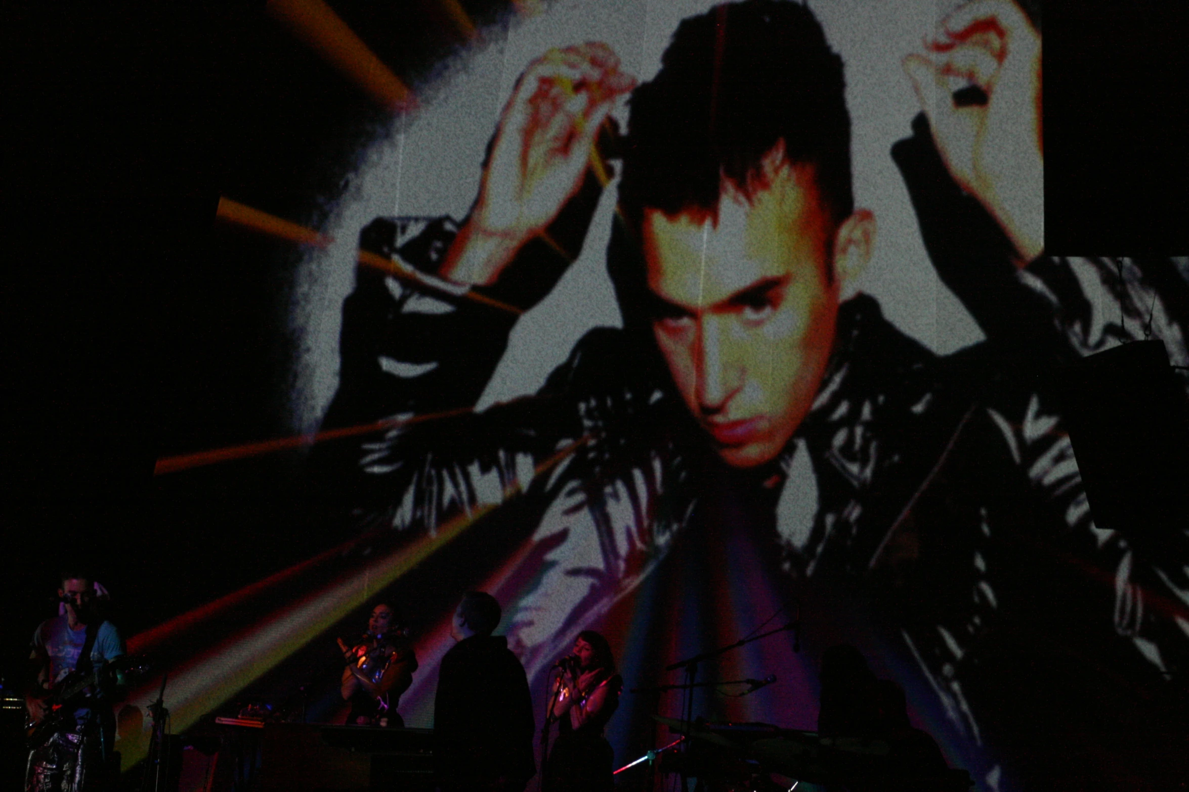 a man standing in front of a screen holding a microphone