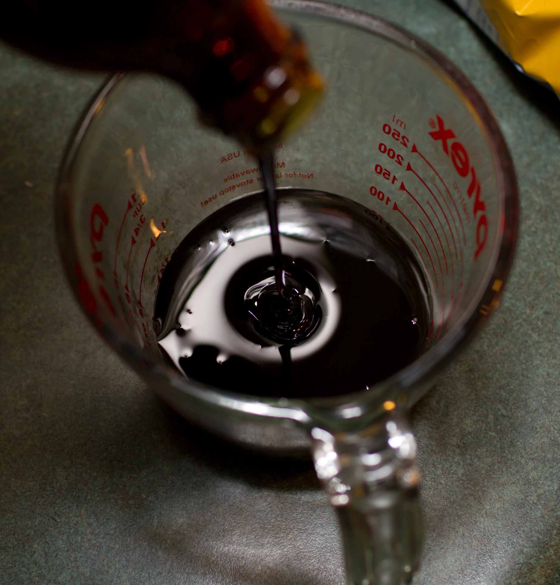 someone adding water in a glass to make black drink