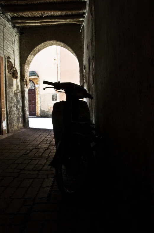 a motorcycle parked in an alley with a tunnel