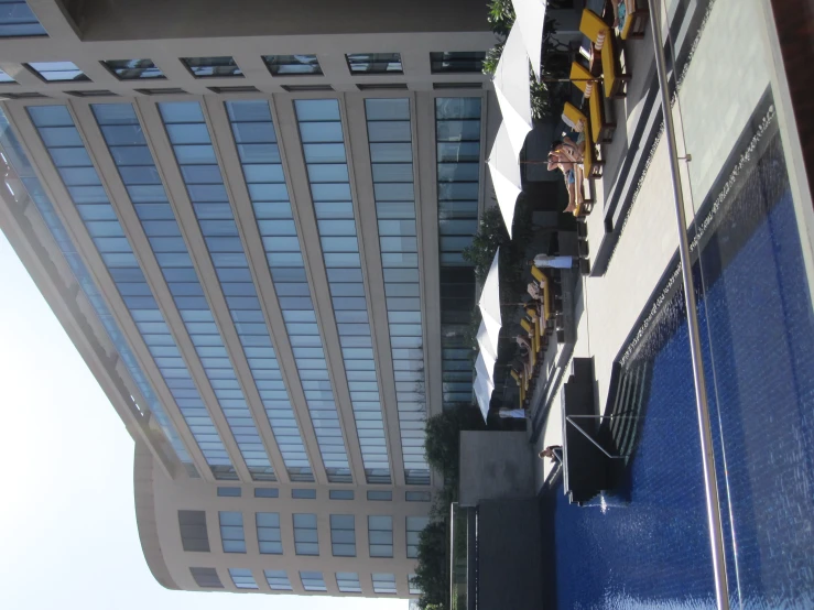 many sunbathers lined up near the swimming pool