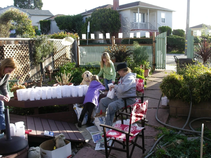 a group of people sitting on chairs around the house