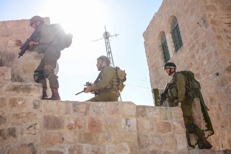 four men in military uniform stand on a stone ramp