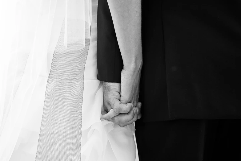 a bride and groom hold hands together holding hands