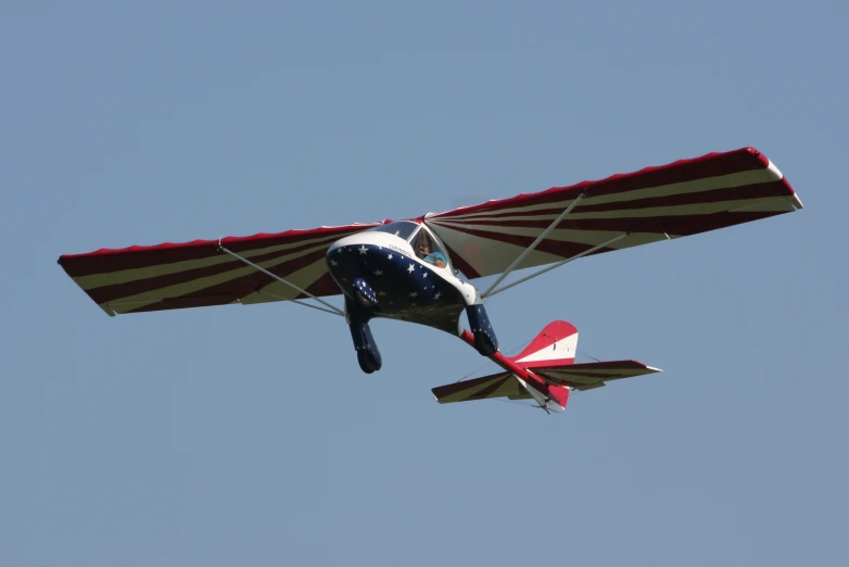 a small airplane in the sky with a long wing