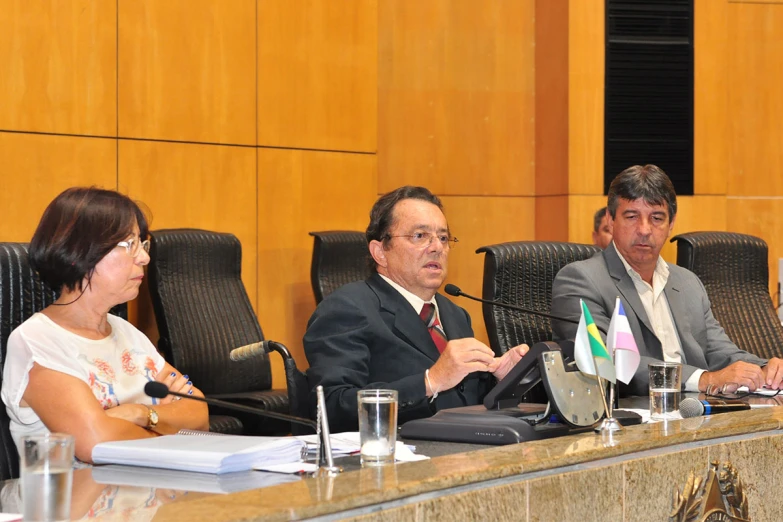 four people sitting down in chairs around a conference table