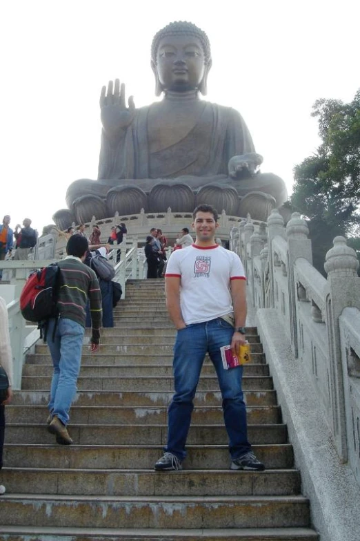 a man standing on the steps in front of a statue