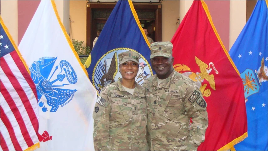a soldier and woman are in front of flags
