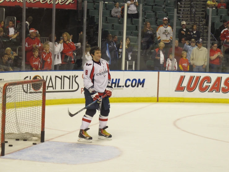 hockey player walking up to net in game