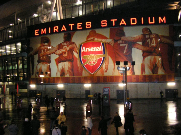 a group of people walking outside of a stadium