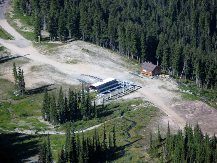 an aerial view of a building site nestled in the middle of the trees