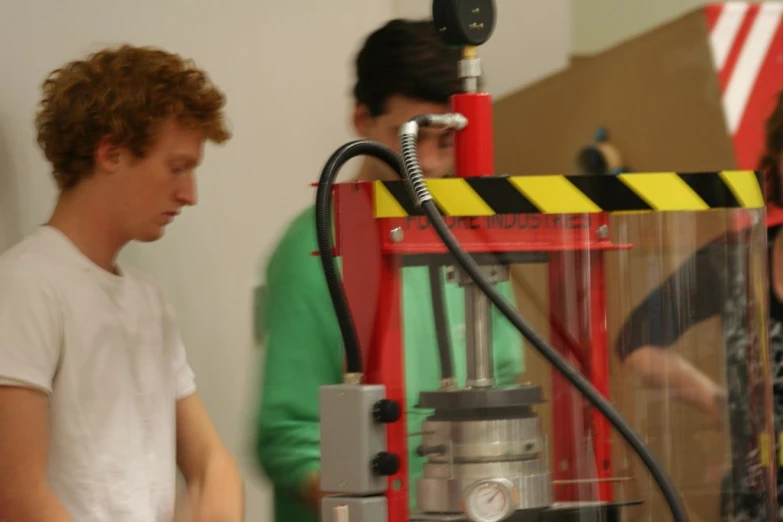 a young man standing next to a large machine