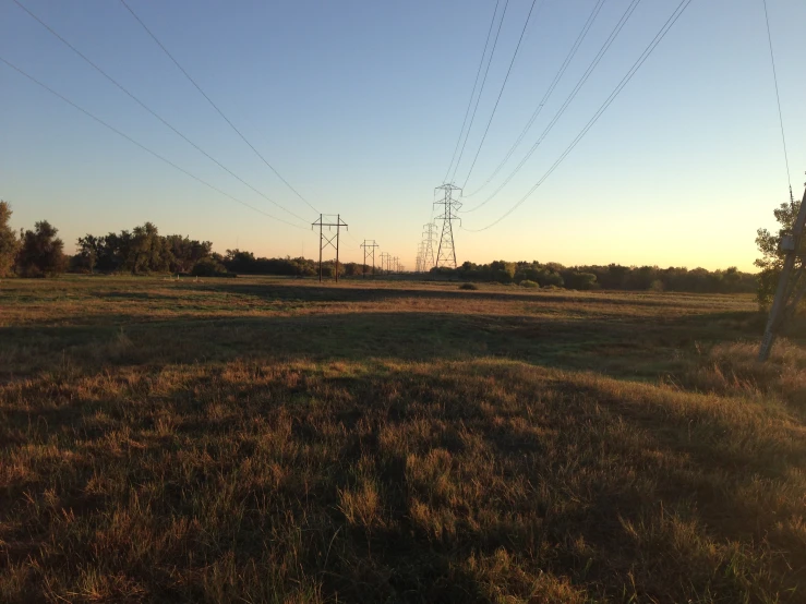 a field with multiple electric towers in the distance