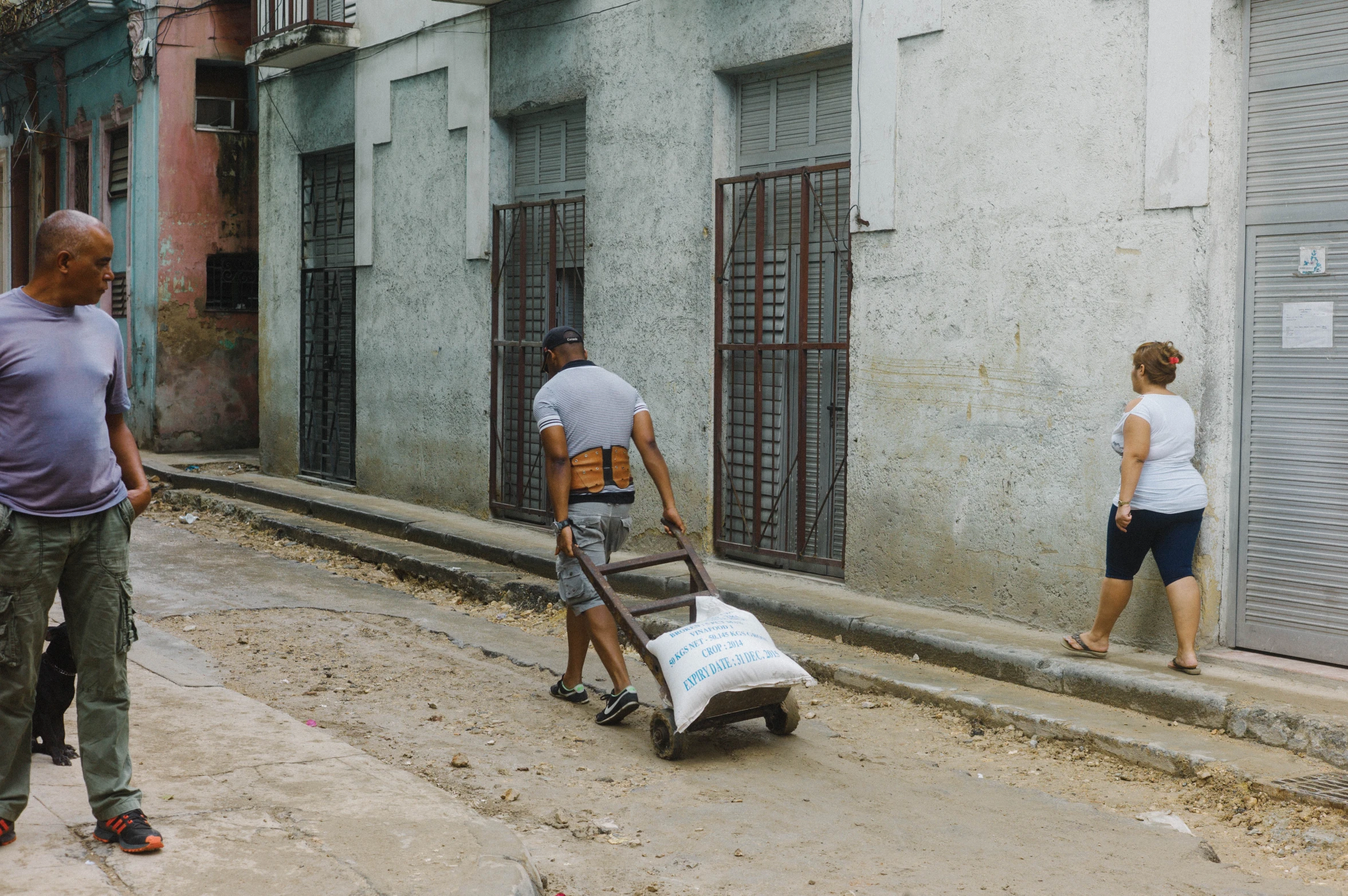 a man with a dolly hing a cart in front of a building