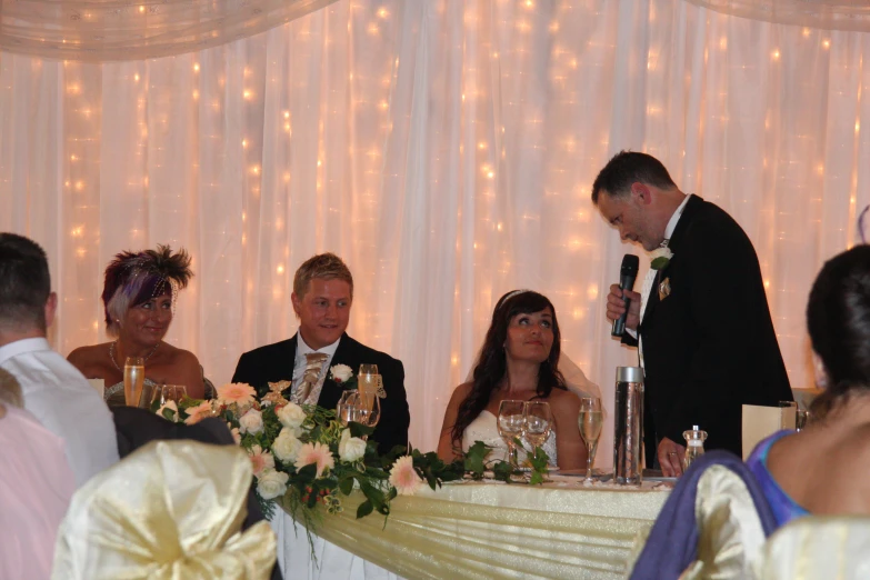 the man and woman are standing in front of the wedding microphone