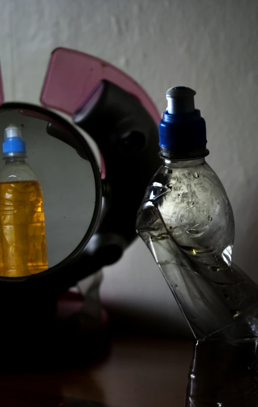 a bottle of cleaner sits in front of a mirror
