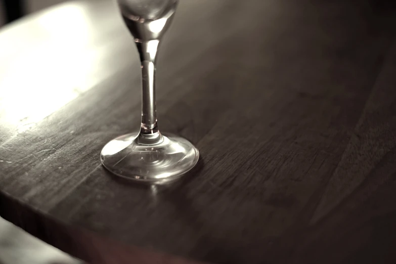 a clear wine glass sitting on top of a wooden table