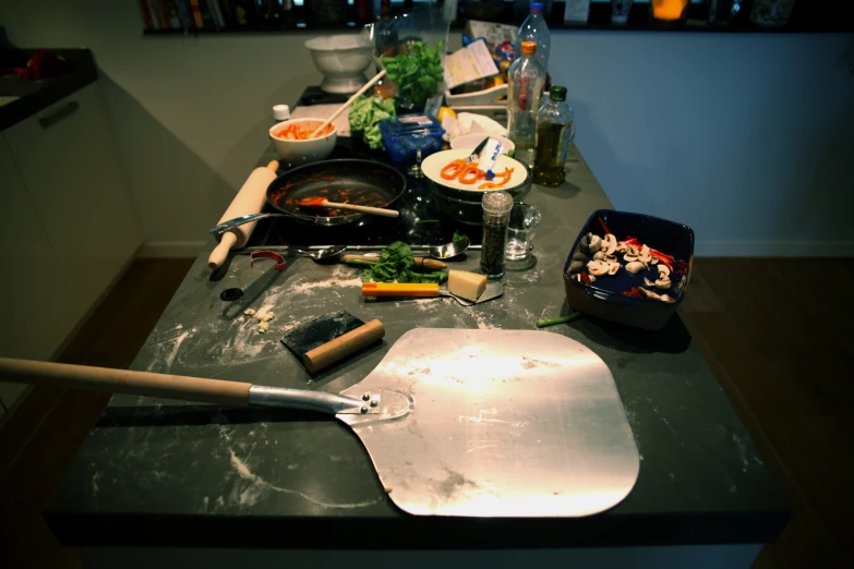 an oven table is loaded with baking utensils and food