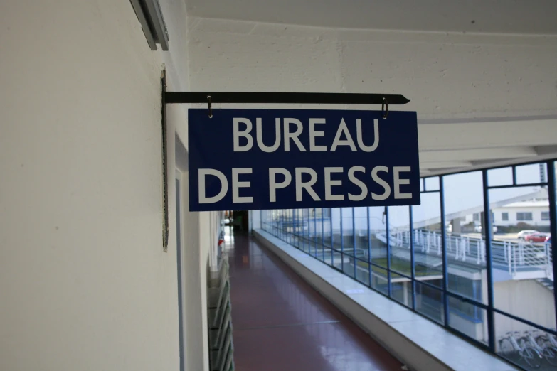 a sign hangs near a railing that says bureau de presse