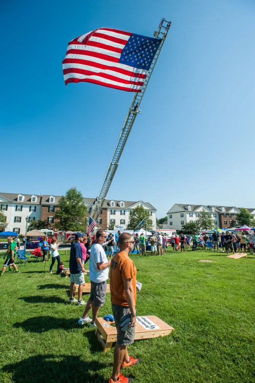 a man standing on a bench in the middle of a grassy area with an american flag