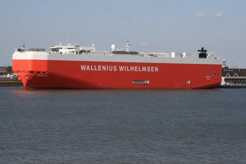 a large red and white ship is docked in the water