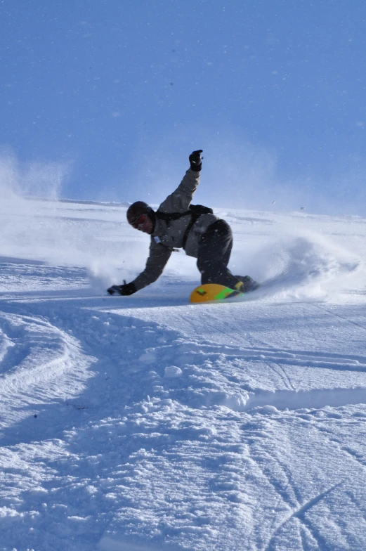 a person riding a snowboard down a snowy slope