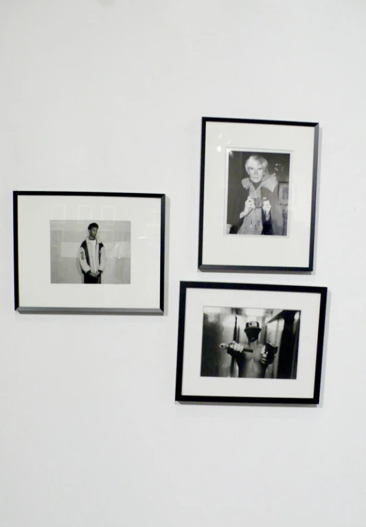 three black and white framed pictures on the wall