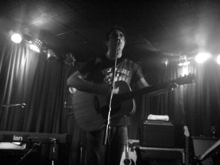 a guy playing a guitar in front of a crowd